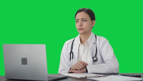 Serious-Indian-female-doctor-consulting-patient-on-video-call-Green-screen