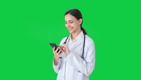 Happy-Indian-female-doctor-using-phone-Green-screen
