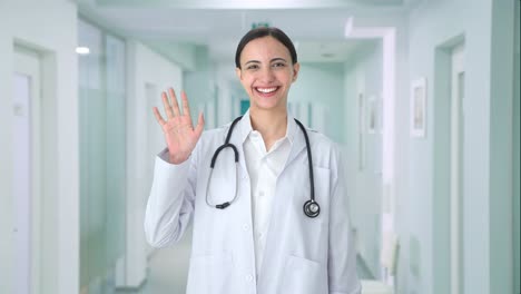 Happy-Indian-female-doctor-waving-Hi-to-the-camera