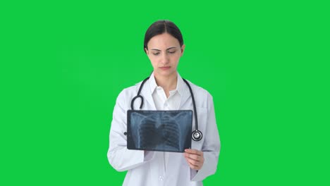Serious-Indian-female-doctor-checking-X-ray-Green-screen