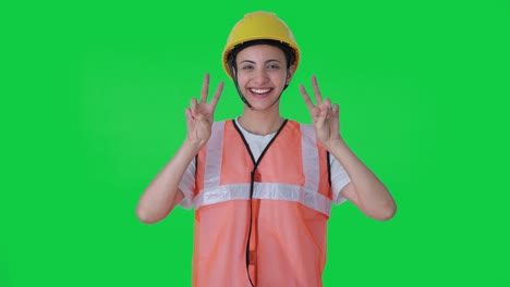 Happy-Indian-female-construction-worker-showing-victory-sign-Green-screen