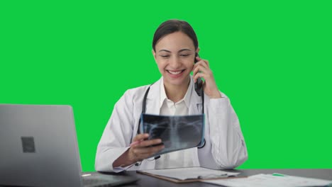 Happy-Indian-female-doctor-explaining-X-ray-to-patient-on-call-Green-screen