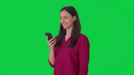 Happy-Indian-girl-looking-at-phone-Green-screen
