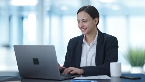 Happy-Indian-female-manager-working-on-laptop