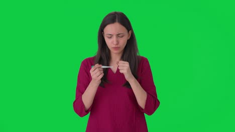 Sick-Indian-girl-checking-fever-using-thermometer-Green-screen