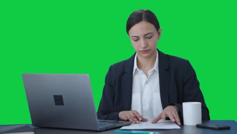 Serious-Indian-female-manager-working-on-laptop-Green-screen