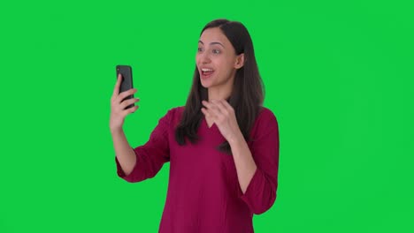Glückliche-Indische-Frau,-Die-über-Einen-Videoanruf-Auf-Grünem-Bildschirm-Spricht
