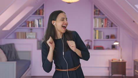 Happy-Indian-girl-listening-to-songs-through-earphone-and-dancing