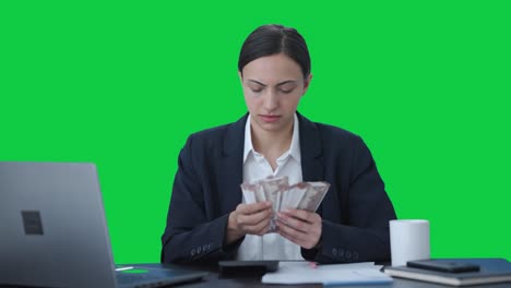 Serious-Indian-business-woman-counting-money-Green-screen