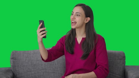 Glückliche-Indische-Frau,-Die-Mit-Jemandem-über-Einen-Videoanruf-Auf-Grünem-Bildschirm-Spricht
