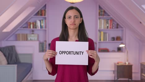 Sad-Indian-woman-holding-OPPORTUNITY-banner