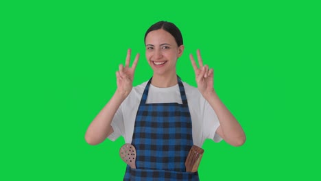 Happy-Indian-housewife-showing-victory-sign-Green-screen