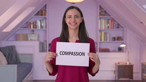 Happy-Indian-woman-holding-COMPASSION-banner