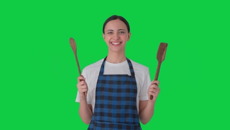 Happy-Indian-housewife-posing-with-spoon-and-spatula-Green-screen