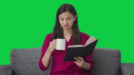 Annoyed-Indian-woman-reading-a-book-and-drinking-coffee-Green-screen