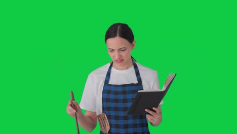Confused-Indian-housewife-making-food-from-recipe-book-Green-screen