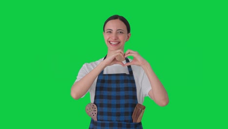 Glückliche-Indische-Hausfrau,-Die-Ein-Herzzeichen-Auf-Grünem-Bildschirm-Macht