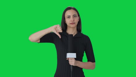 Upset-Indian-female-news-reporter-showing-thumbs-down-Green-screen