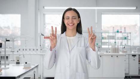 Happy-Indian-female-scientist-showing-victory-sign