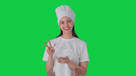 Happy-Indian-female-professional-chef-noting-down-recipe-Green-screen