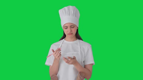 Confused-Indian-female-professional-chef-noting-down-recipe-Green-screen