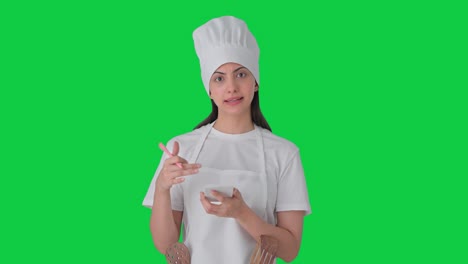 Indian-female-professional-chef-noting-down-recipe-Green-screen