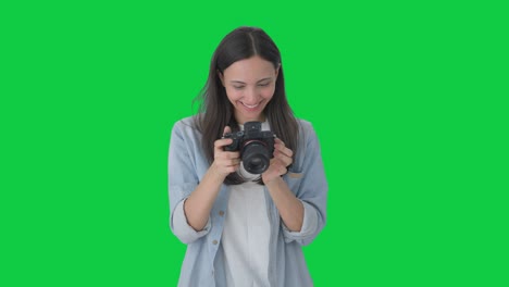 Happy-Indian-girl-clicking-photos-using-a-camera-Green-screen