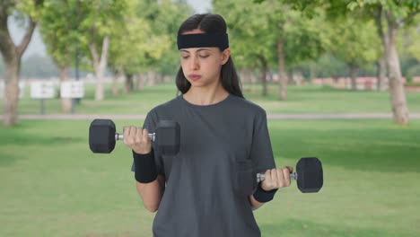 Serious-Indian-girl-lifting-heavy-dumbbells