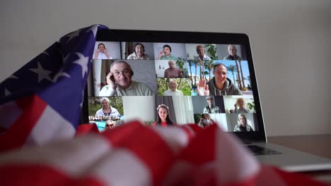 Online-party-with-loved-ones-from-USA.-Celebrating-video-chat.-Virtual-party-via-video-messenger.-Americans-are-video-chatting.-flag-of-America-next-to-computer