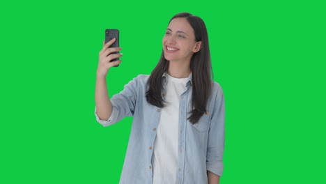 Fröhliches-Indisches-Mädchen,-Das-über-Einen-Videoanruf-Auf-Grünem-Bildschirm-Spricht