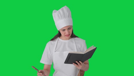 Confused-Indian-female-professional-chef-making-food-from-book-Green-screen