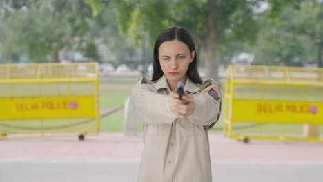 Angry-Indian-female-police-officer-aiming-handgun-on-someone