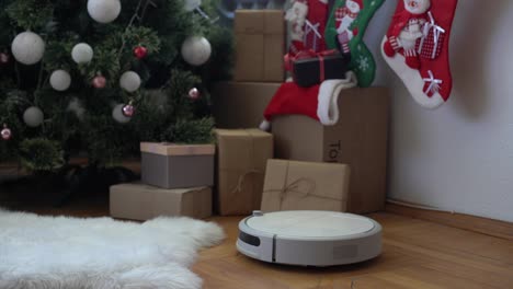 Smart-home.-Robot-vacuum-cleaner-performs-automatic-cleaning-of-the-apartment-at-a-certain-time.-Cleans-the-parquet-from-Christmas-tree-needles-after-the-new-year.