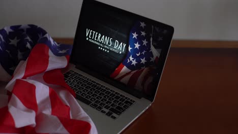 Veteranentag-Geschrieben-In-Laptop-Mit-Flagge-Der-Vereinigten-Staaten,-Auf-Einem-Rustikalen-Holzhintergrund