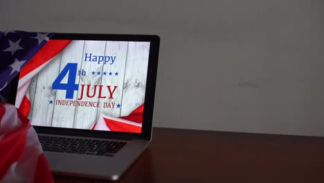 American-flags-with-inscription-Happy-Independence-Day-on-laptop