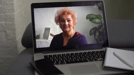 Happy-older-mature-60s-woman-indoor-head-shot-portrait.-Cheerful-elder-lady-wearing-eye-glasses,-casual,-looking-at-camera-with-toothy-smile,-posing-at-home,-laughing.-Video-call-screen