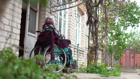 Alte-Einsame-Frau-Sitzt-In-Einem-Rollstuhl-Am-Fenster-In-Seinem-Haus