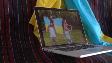 laptop-with-video-conference-and-presentation-near-the-flag-of-ukraine.