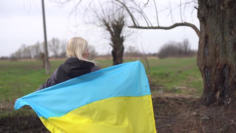 woman-flag-of-ukraine-near-burnt-tree