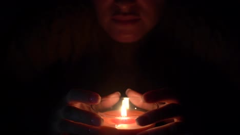 The-candle-is-lit-in-a-glass-held-by-a-beautiful-woman-in-black.-Isolated-on-the-concept-of-saving-the-earth's-energy.-Earth-hour