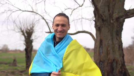Erfolgreicher-Silhouette-Mann-Sieger-Schwenkt-Ukrainische-Flagge-In-Der-Nähe-Eines-Verbrannten-Baumes