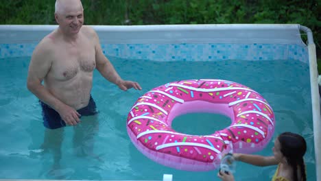 grandfather-and-granddaughter-swimming-in-the-pool
