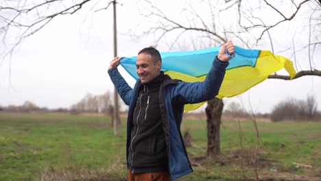 man-with-the-flag-of-Ukraine-near-the-burnt-tree
