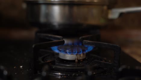 Closeup-shot-of-blue-fire-from-domestic-kitchen-stove-top.-Gas-cooker-with-burning-flames-of-propane-gas.-Industrial-resources-and-economy-concept