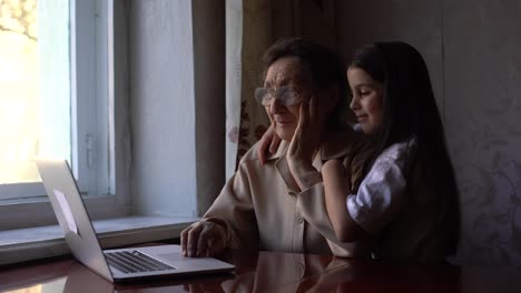 Great-Grandmother-and-granddaughter-wave-to-family-on-computer