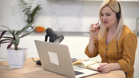 Una-Mujer-Con-Auriculares-Se-Comunica-Mediante-Videollamada-En-Una-Computadora-Portátil