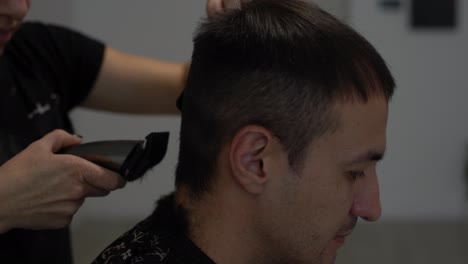 Barber-cutting-hair-with-clipper