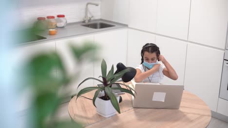 little-schoolgirl-takes-off-her-mask-and-headphones-after-taking-online-lessons