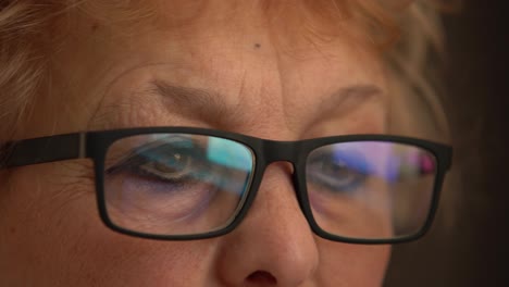 CLOSE-UP:-elderly-woman-with-glasses-working-on-PC.-Eyes-reflecting-monitor