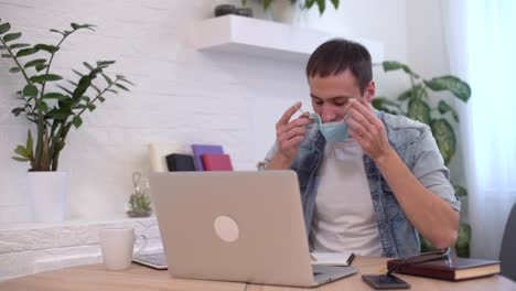 Portrait-of-young-businessman-takes-off-face-mask-at-workplace.-Safe-work-in-pandemic-time